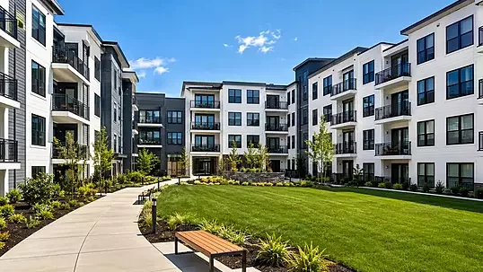 Modern multifamily apartment community with a landscaped courtyard and walking path.